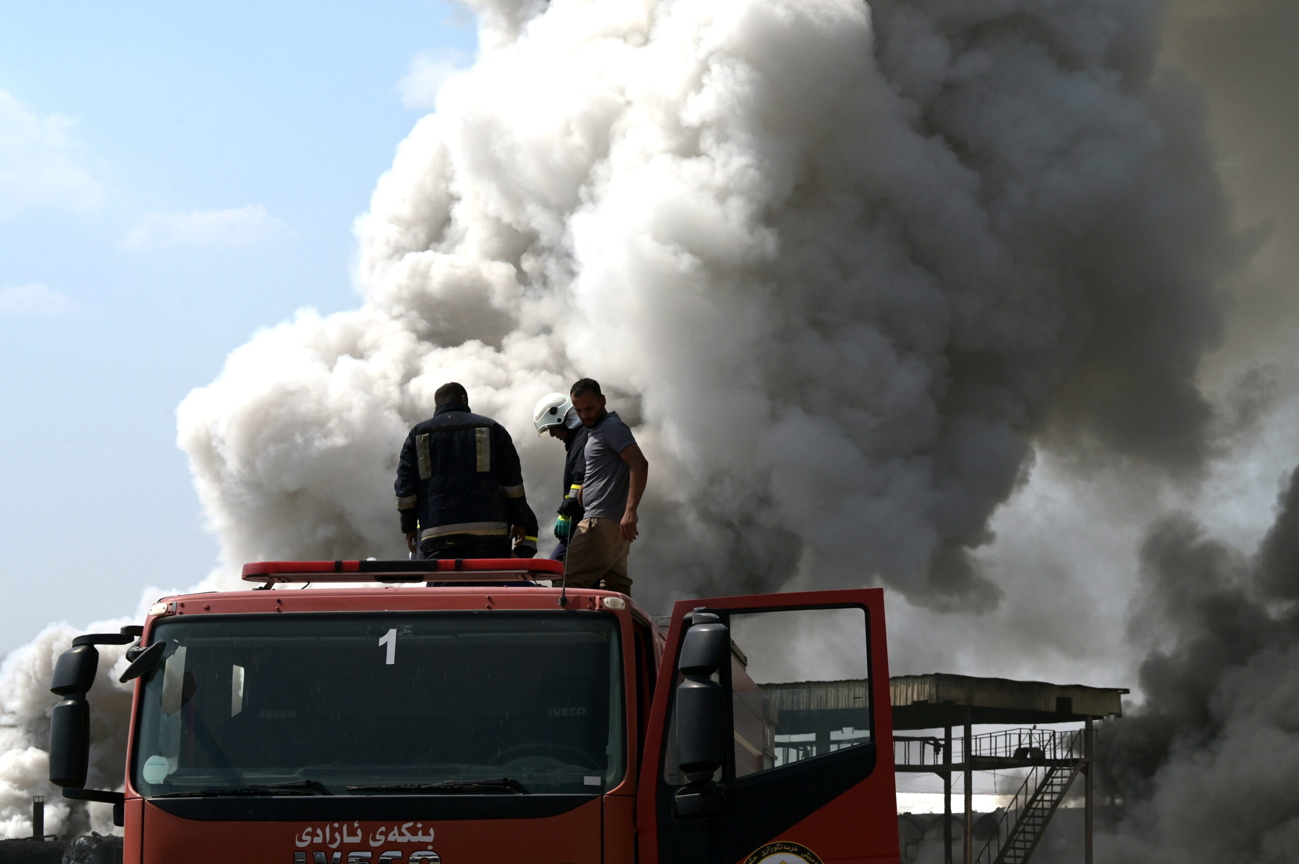 Firefighters try to stop a fire burning at an oil refinery near Erbil, northern Iraq, 13 June 2024. The fire broke out in fuel storage facilities and asphalt processing units raging late 12 June 2024. More than 10 firefighters were injured, and three fire engines were damaged in the attempt to control the fire, which remains uncontained, according to local security officials