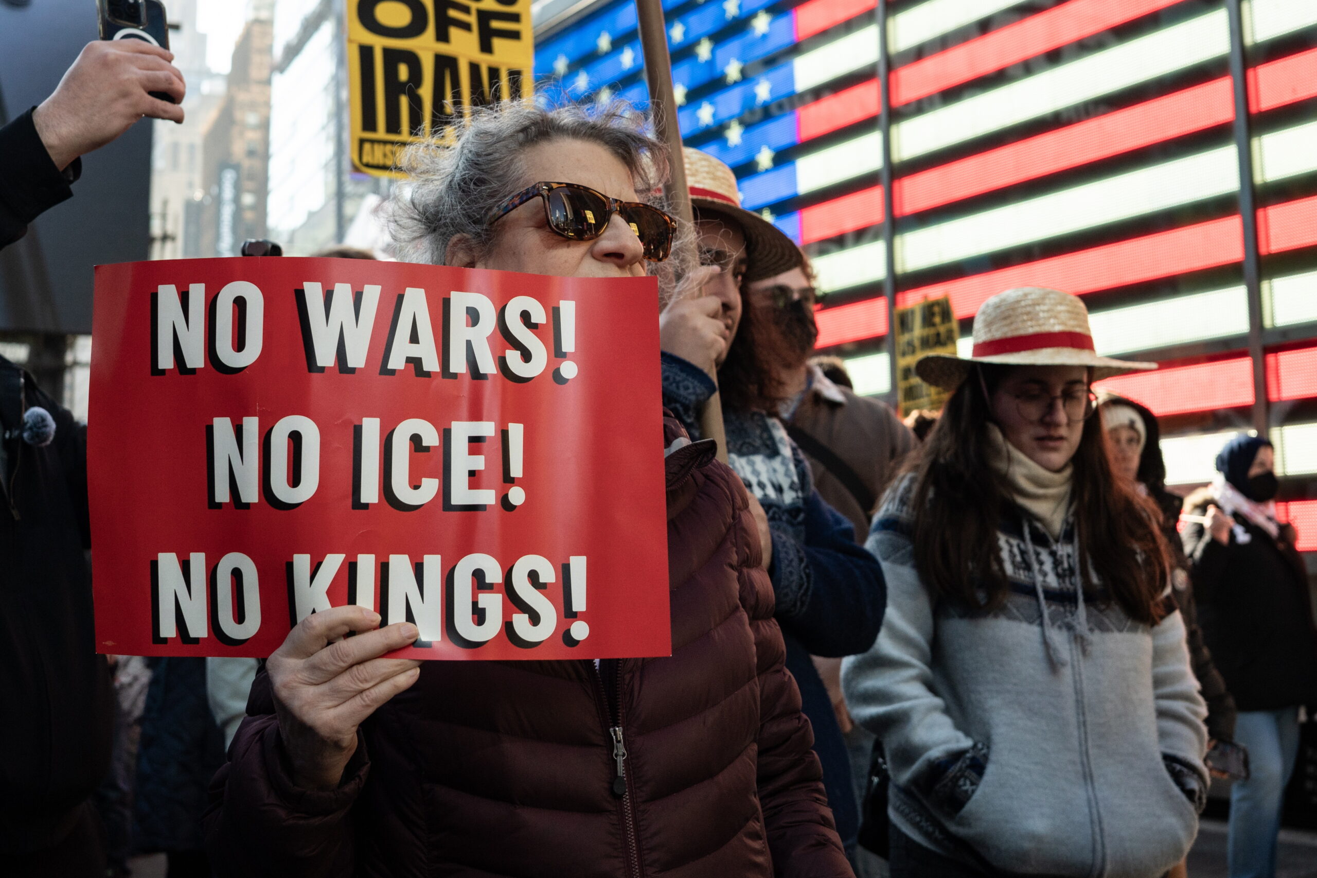 woman holds a sign that reads 'No Wars! No ICE! No Kings!' during a protest against United States (US) military strikes on Iran, at Times Square in New York, New York, USA, 28 February 2026. Israel and the US military conducted joint strikes targeting multiple locations in Iran in the early hours of 28 February 2026, prompting immediate demonstrations across several US cities.