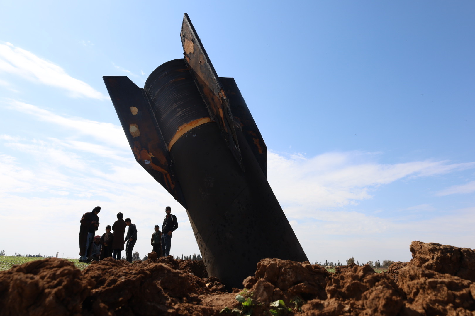 People stand next to an Iranian missile that fell in the village of Qazaljo in the Qamishli countryside, Syria, on 04 March 2026. Iran launched retaliatory attacks across the region following a joint Israeli-US military operation that started in the early hours of 28 February 2026, targeting multiple locations across Iran.