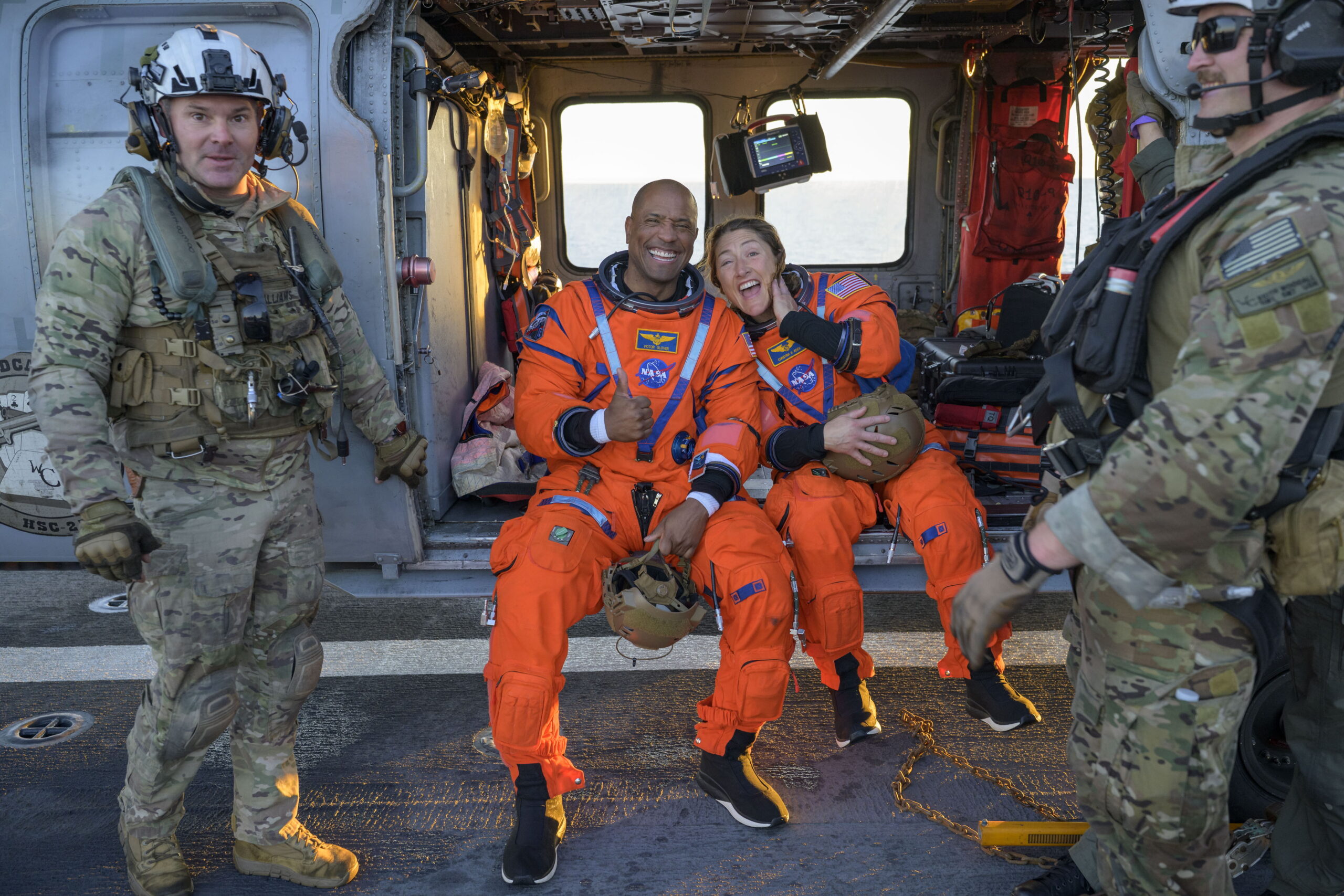 A handout photo made available by the National Aeronautics and Space Administration (NASA) shows NASA astronaut Victor Glover (L), Artemis II pilot, and NASA astronaut Christina Koch, Artemis II mission specialist are seen sitting on a Navy MH-60 Seahawk from Helicopter Sea Combat Squadron (HSC) 23 on the flight deck of USS John P. Murtha after they and fellow crewmates CSA (Canadian Space Agency) astronaut Jeremy Hansen, Artemis II mission specialist, and NASA astronaut Reid Wiseman, Artemis II commander, were extracted from their Orion spacecraft after splashdown, in the Pacific Ocean off the coast of California, 10 April 2026. NASA’s Artemis II mission took the quartet on a nearly 10-day journey around the Moon and back to Earth. Following a splashdown at 5:07 p.m. PDT (8:07 p.m. EDT), NASA, U.S. Navy, and U.S. Air Force teams worked to bring the Orion spacecraft aboard the recovery ship.