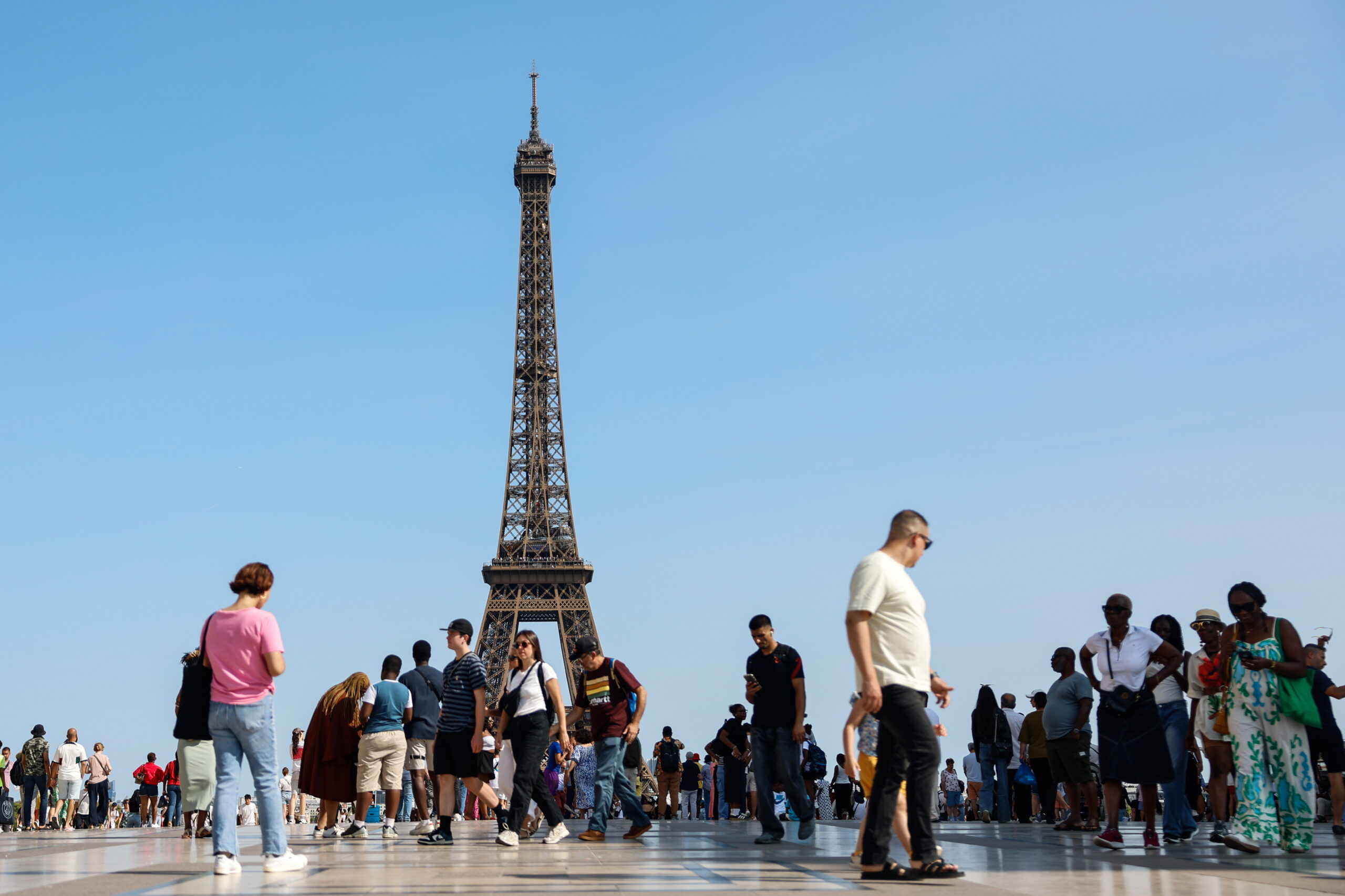 People walk on the Esplanade de Trocadero in front of the Eiffel Tower during a heatwave in Paris, France, 10 August 2025. France experiences high temperatures across the country.