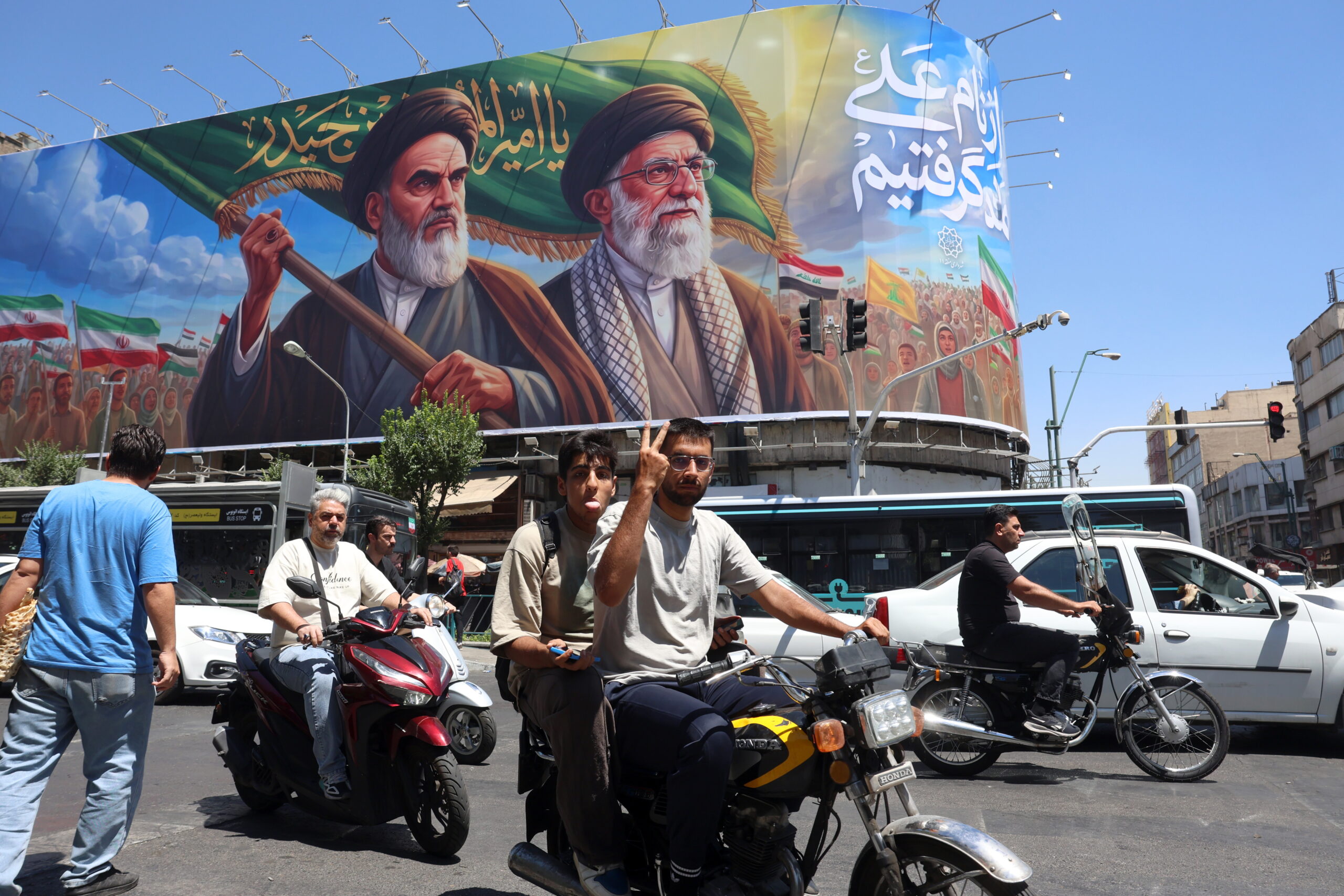 An Iranian shows a victory sign as he drives past a billboard of the late Iranian supreme leaders Ayatollah Ruhollah Khomeini and Ayatollah Ali Khamenei on a street in Tehran, Iran, 15 June 2026. US President Donald Trump announced on his social media platform that a deal with Iran has been reached and is set to be signed on 19 June in Switzerland.