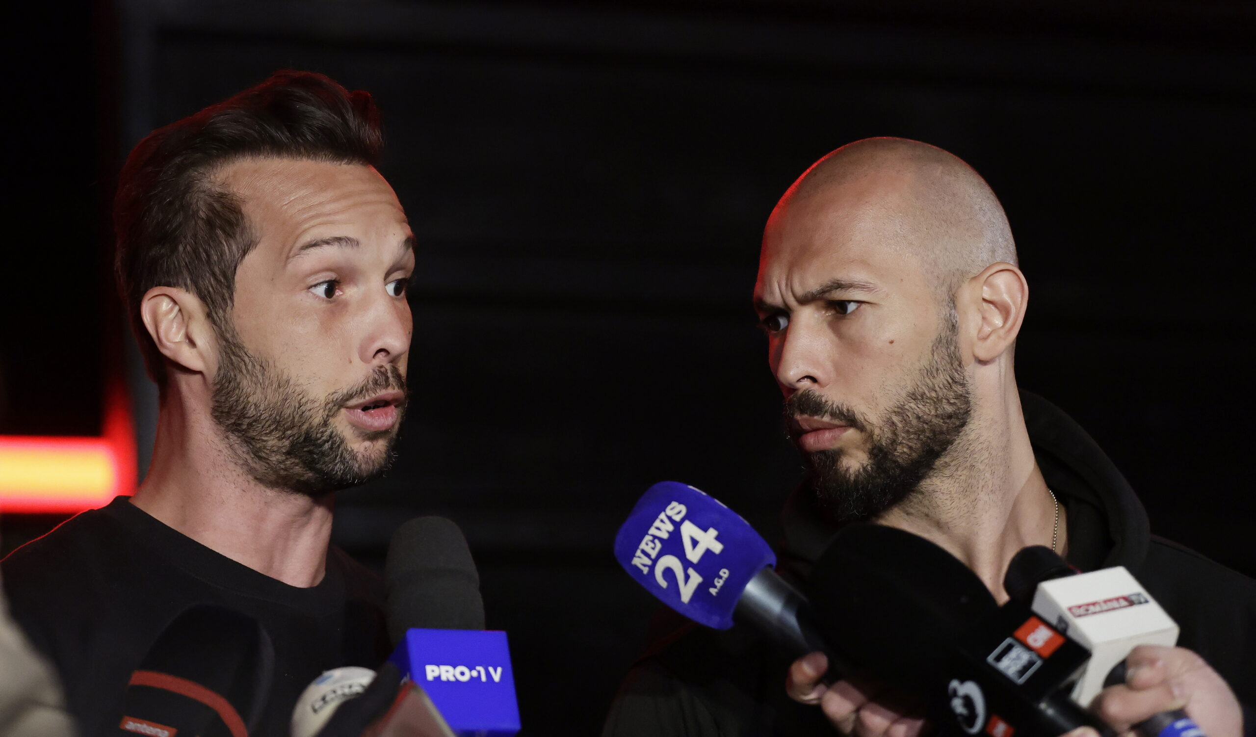 epa11980130 Former professional kickboxer and social media influencer Andrew Tate (R), accompanied by his brother Tristan (L), speaks with TV reporters after returning from a trip in the United States, in front of their property, in Bucharest, Romania, early 22 March 2025. After spending weeks in the USA, Tate brothers returned to Romania, where they face legal charges. Andrew Tate and his brother Tristan were arrested on 29 December 2022 as a result of the DIICOT (Directorate for Investigating Organized Crime and Terrorism) inquiry on charges of human trafficking and intention to form an organized crime group. Romanian police allege that the two brothers and their associates coerced victims for creating a paid pornography service for social media platforms. The trial itself has not started yet, as the appeal court judges sent the case back to DIICOT prosecutors by a decision made at the end of 2024.