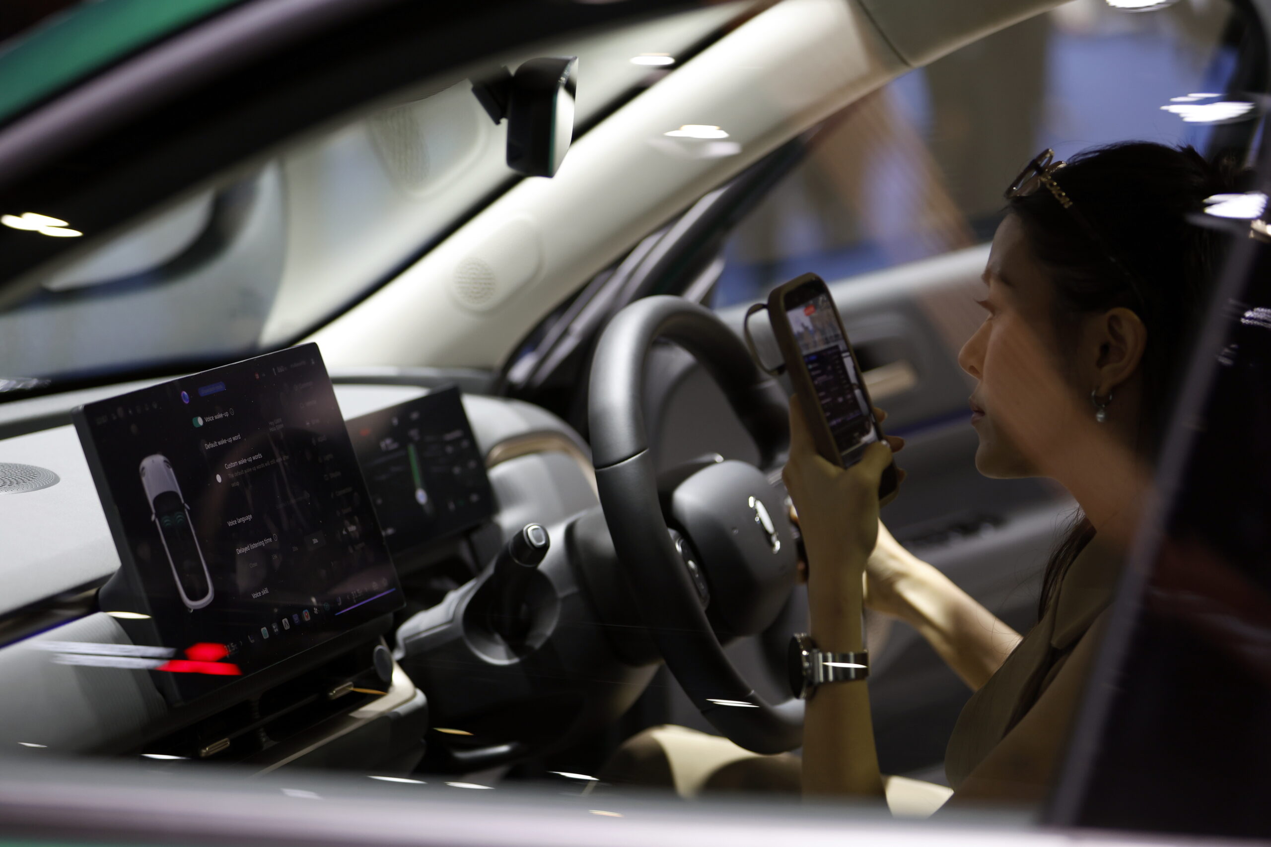 A woman inspects a GWM ORA 5 electric car on display at the 47th Bangkok International Motor Show 2026 in Nonthaburi, on the outskirts of Bangkok, Thailand, 23 March 2026. Forty-five major automaker and motorcycle brands will showcase their products, including new electric vehicles, where organizers, Grand Prix International Public Company, predict rising fuel prices will drive consumer demand toward electric vehicles.