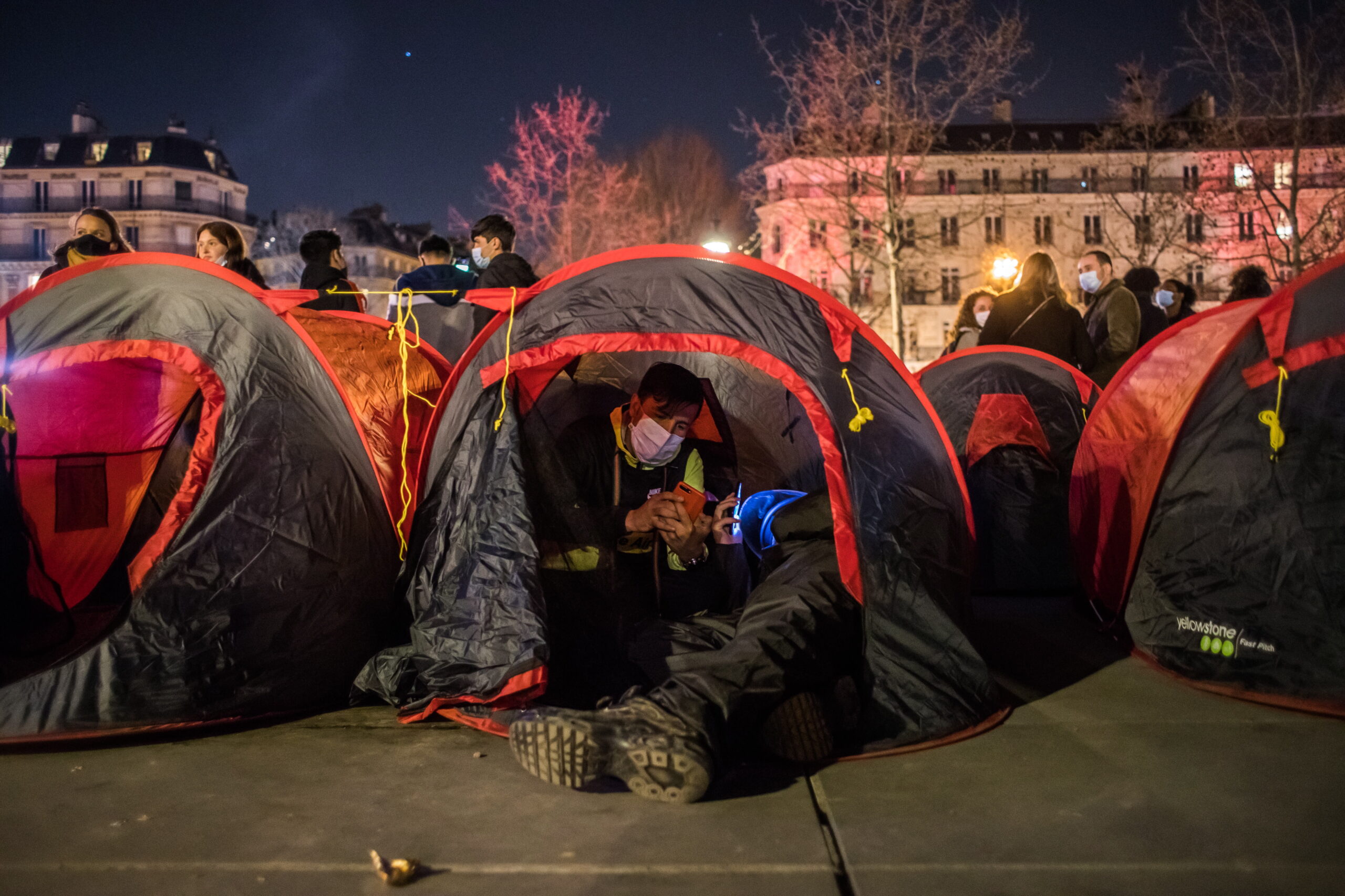 epa09098021 Migrants and their supporters set up tents to form a makeshift migrant camp on Place de la Republique on the occasion of a 'Night of solidarity' at the Place de la Republique in Paris, France, 25 March 2021. The more than 300 homeless people asked for stable and decent accommodation.