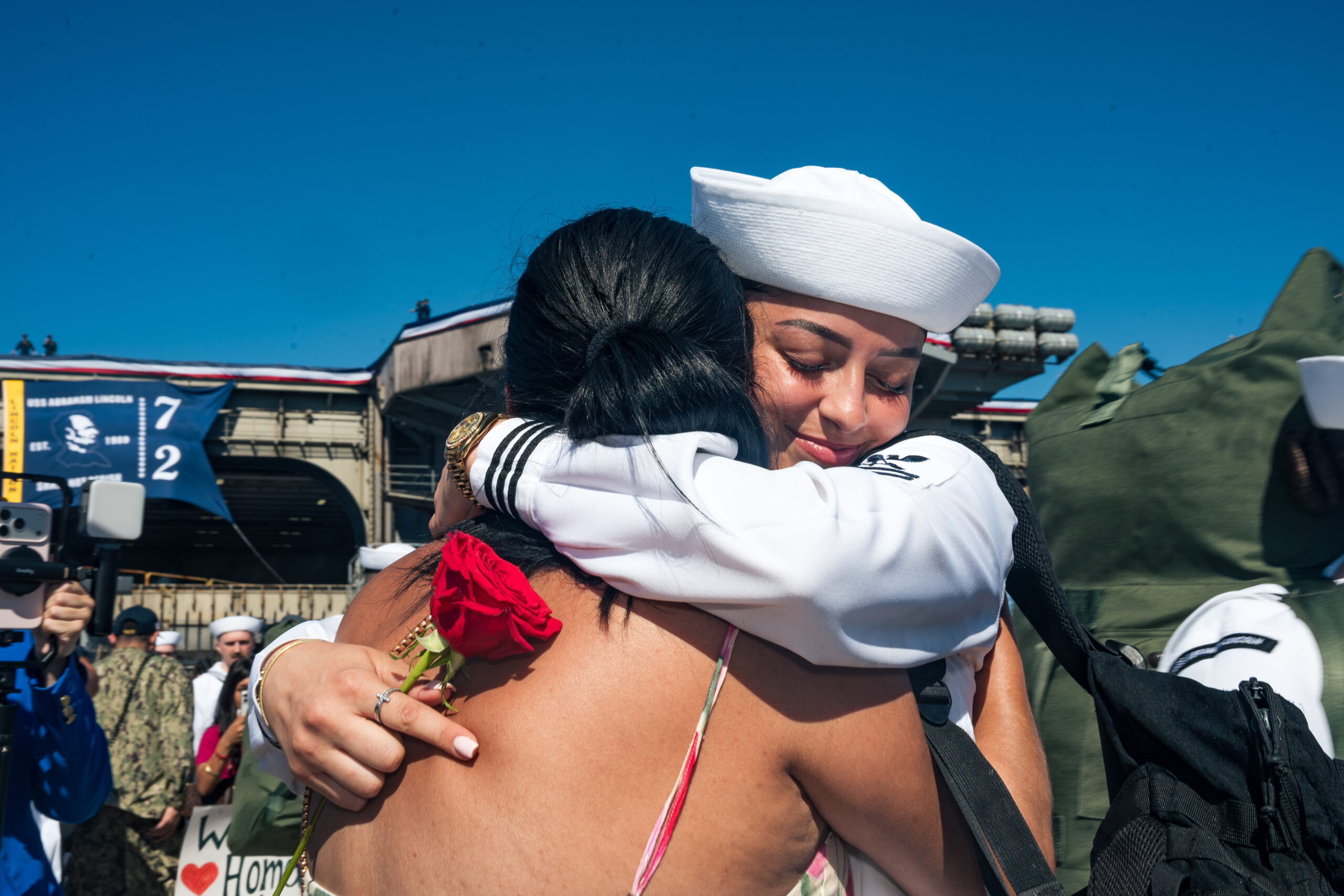 epa13290555 A person embraces a US service member as the USS Abraham Lincoln (CVN-72) returns to its home port at Naval Air Station North Island in San Diego, California, USA, 08 October 2026, following a 321-day deployment. The Nimitz-class aircraft carrier returned after supporting US military operations in the Middle East. The homecoming marked the end of the ship's crew's extended deployment.