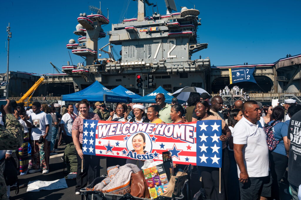 epa13290558 People pose for a picture as the USS Abraham Lincoln (CVN-72) returns to its home port at Naval Air Station North Island in San Diego, California, USA, 08 October 2026, following a 321-day deployment. The Nimitz-class aircraft carrier returned after supporting US military operations in the Middle East. The homecoming marked the end of the ship's crew's extended deployment.  