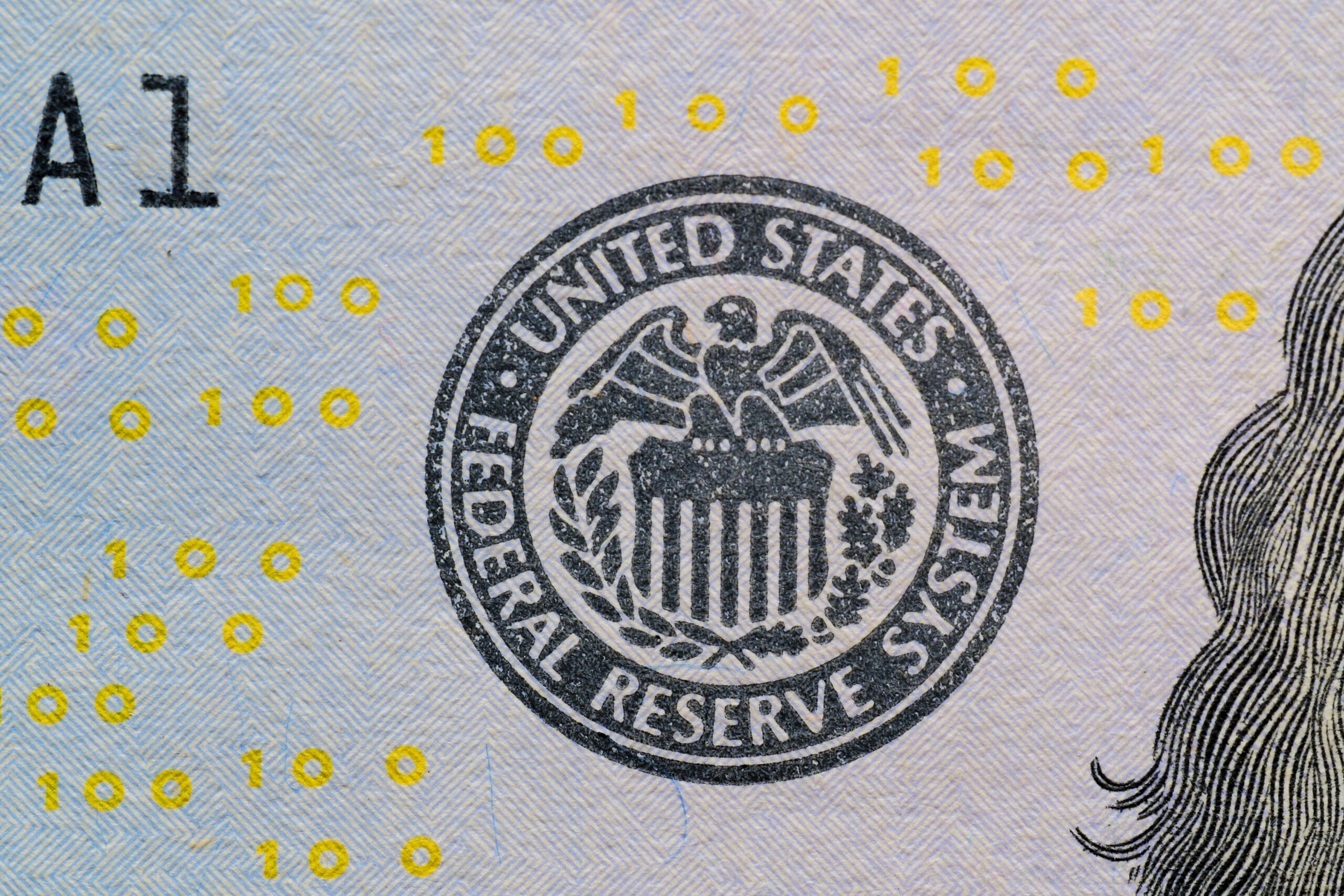 Detailed view of the US Federal Reserve System seal on currency with yellow digital numbers.